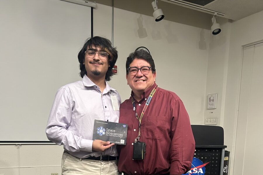 Student participating in NASA Community College Aerospace Scholars (NCAS) program pose for picture in front of airplane