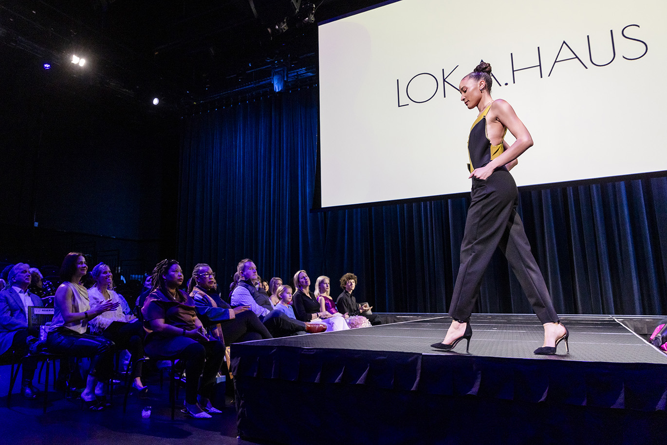 Model in black jumpsuit takes a spin on the runway during the Fashion Show.