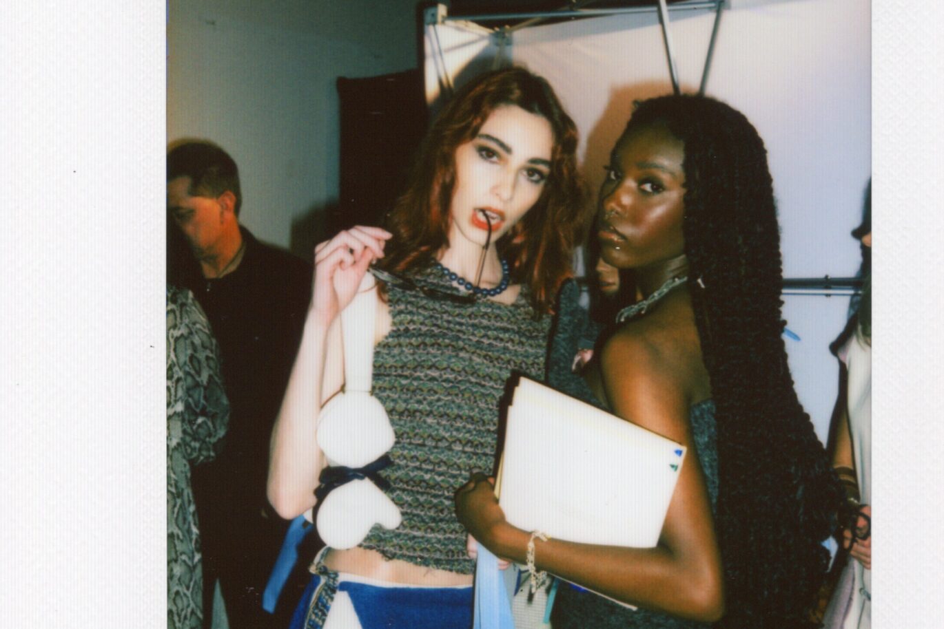 two pose in front of camera before walking the runway