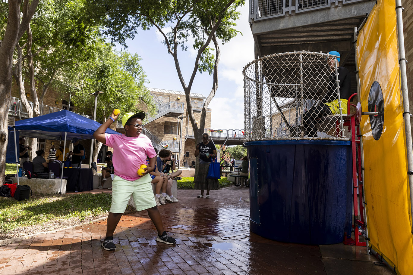 2024 Juneteenth Celebrations A boy throws a ball at a target attached to a dunk tank during an event celebrating Juneteenth.
