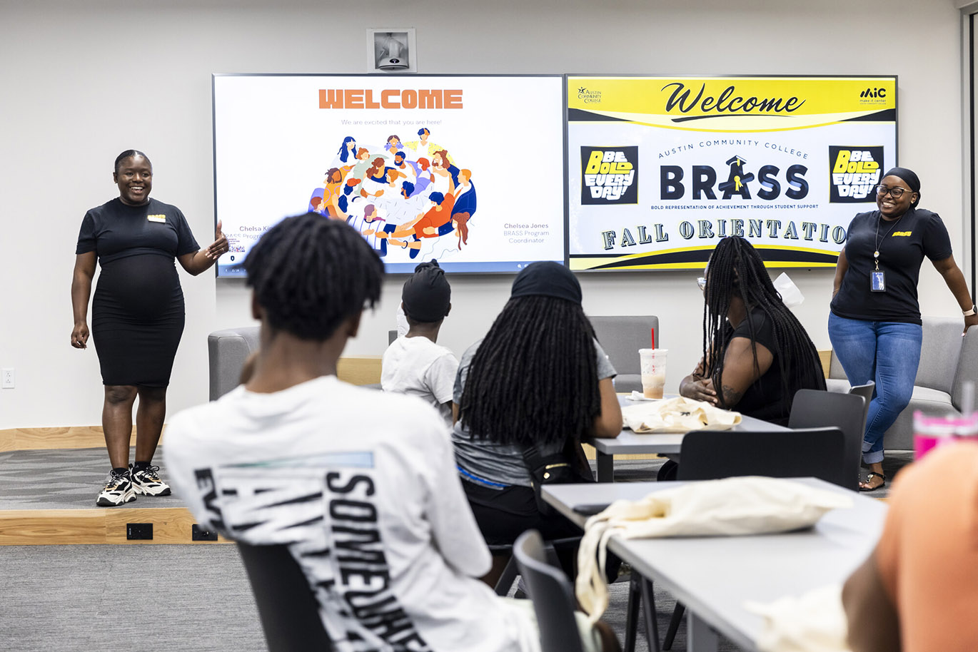 BRASS 2024 Orientation Two female college employees talk to a group of students during an orientation event.