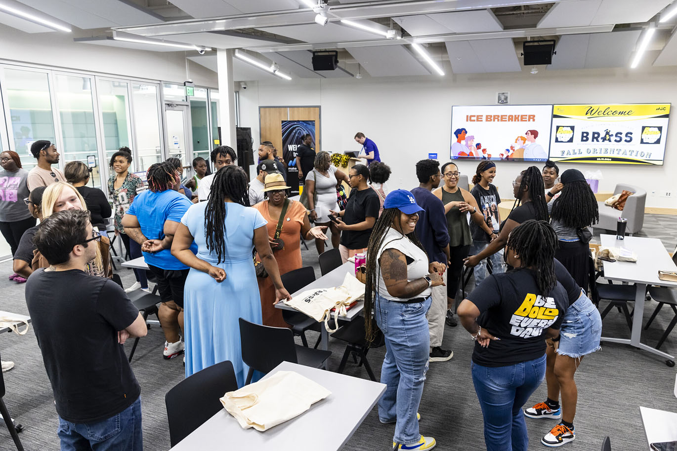 BRASS 2024 Orientation A group of more than twenty college students stand and talk to each other as part of a breaking the ice activity during an orientation event.