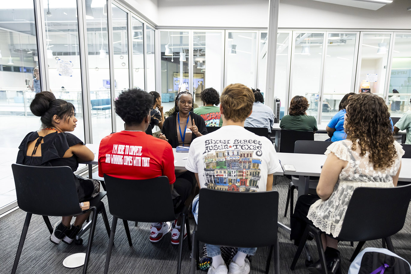 BRASS Mentor & Mentee Event A female college employee talks to four students during a mentor and mentee event.