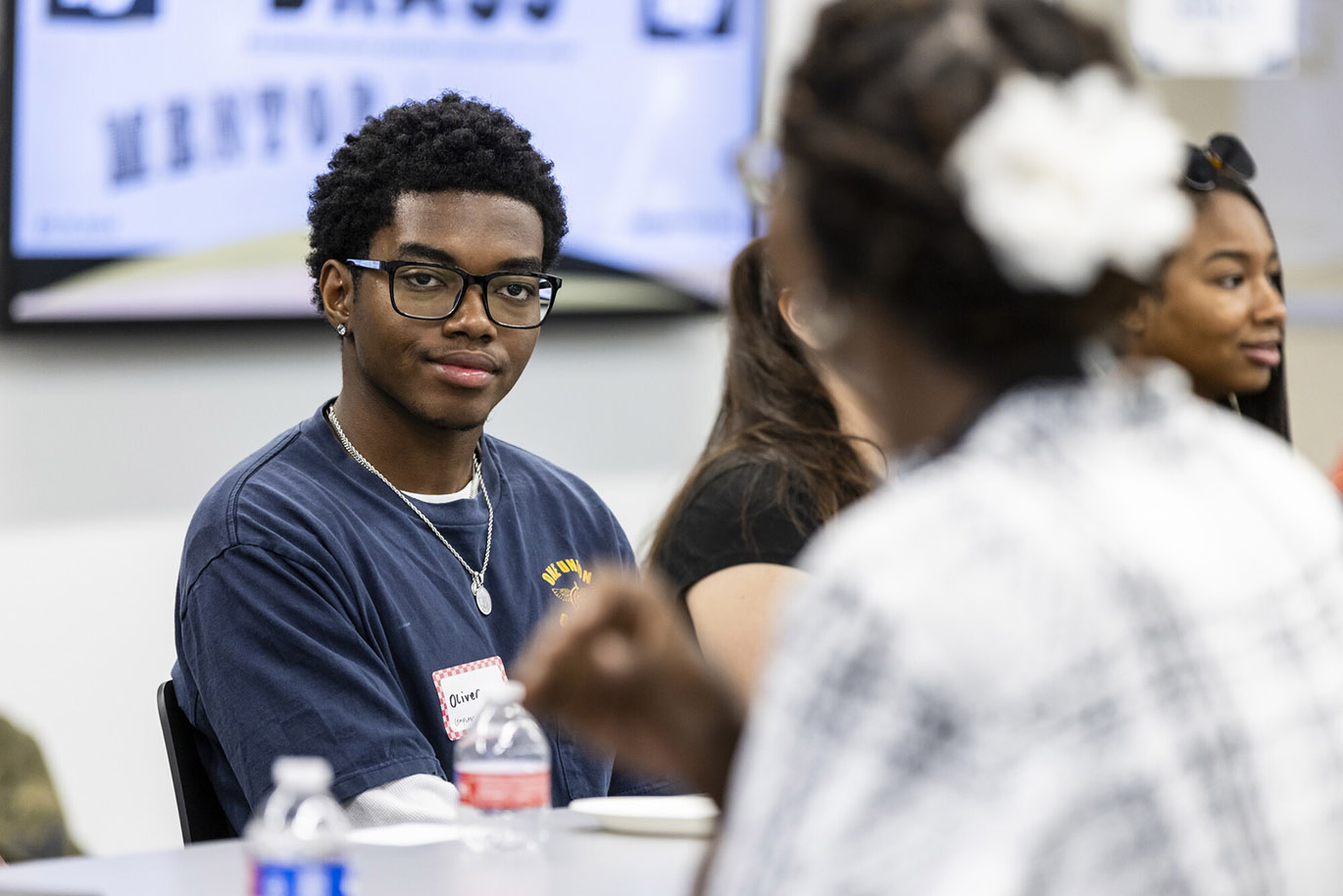 BRASS Mentor & Mentee Event A male college student listens to a college employee during a mentor and mentee event.