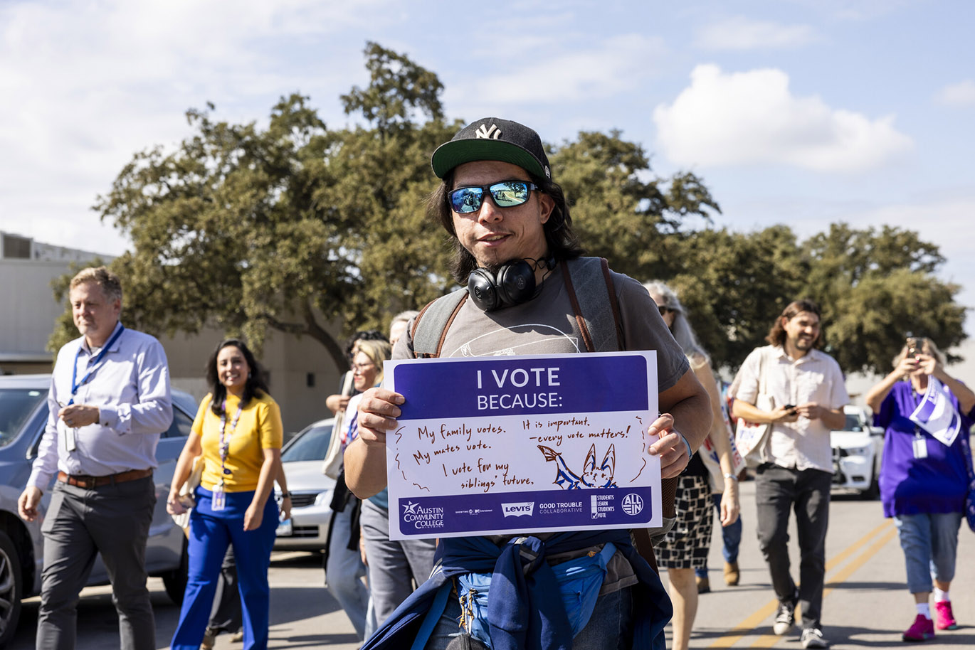 HLC Parade to the Polls A young man holds up a handwritten sign while walking in a parade.