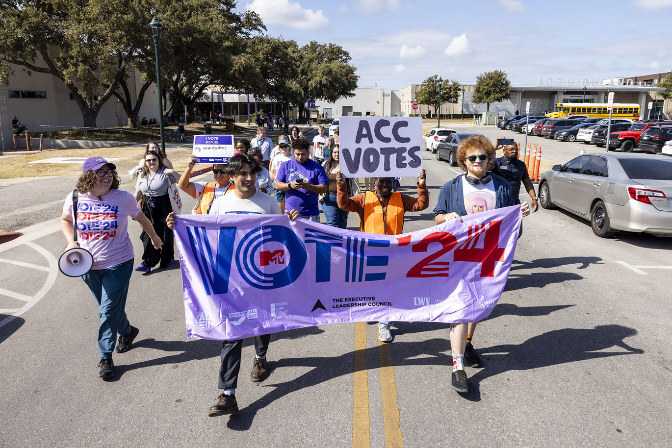 HLC Parade to the Polls A group of people march during a parade to the polls event while holding a large banner with the "Vote '24" printed on it.