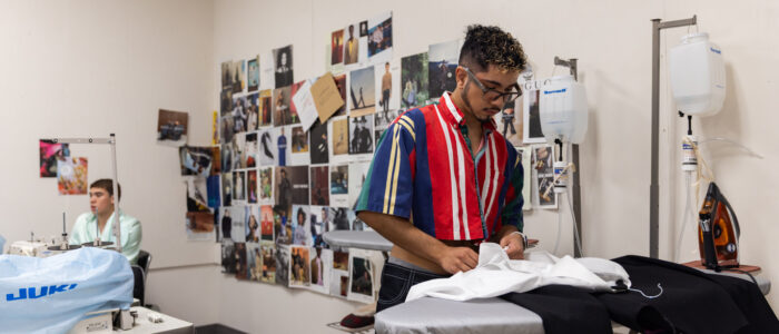 Designer puts the final touches on designs at Visions Fashion Show