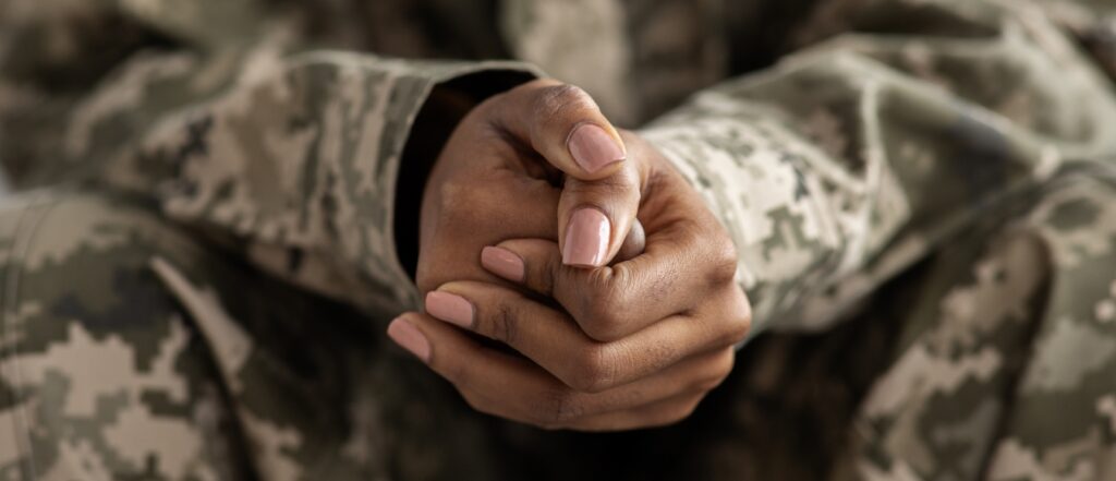 Clasped Hands Of Black Soldier In Camouflage Uniform.